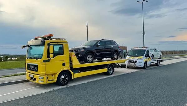 Żółta laweta Viking Auto holuje SUV-a, za nią druga laweta z autem osobowym