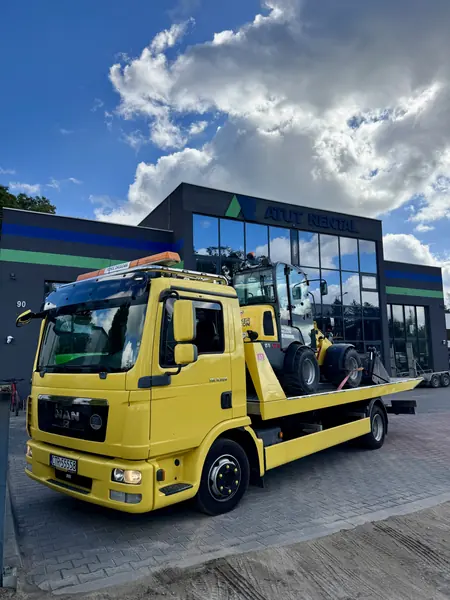 Żółta laweta Viking Auto przewożąca maszynę budowlaną
